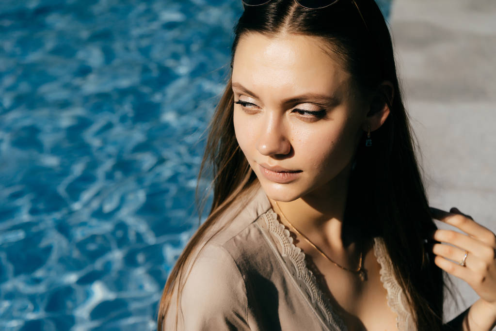 modell vonzó szexi lány élvezi a nap, a háttérben a kék víz - Fotó, kép
