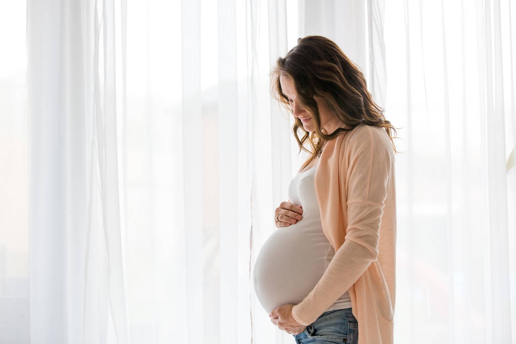 Retrato de jovem grávida atraente mulher, em pé pela vitória
 - Foto, Imagem