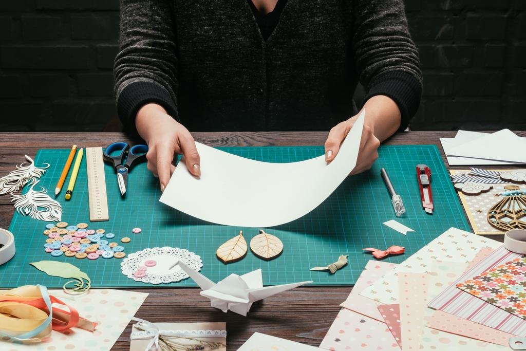imagen recortada de la mujer sosteniendo hoja vacía de papel para scrapbooking postal hecha a mano
 - Foto, Imagen
