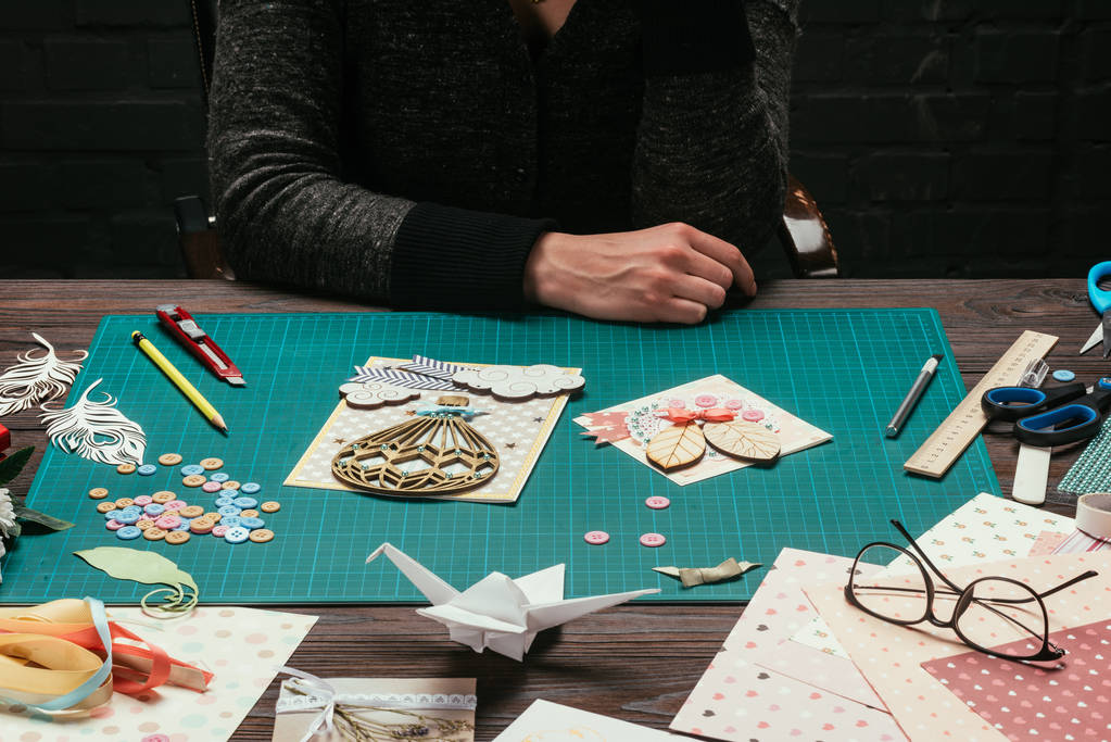 imagen recortada del diseñador de scrapbooking sentado en la mesa de trabajo
 - Foto, Imagen