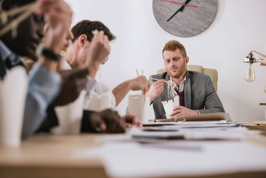 группа бизнесменов, которые вместе едят лапшу в офисе с боссом
 - Фото, изображение