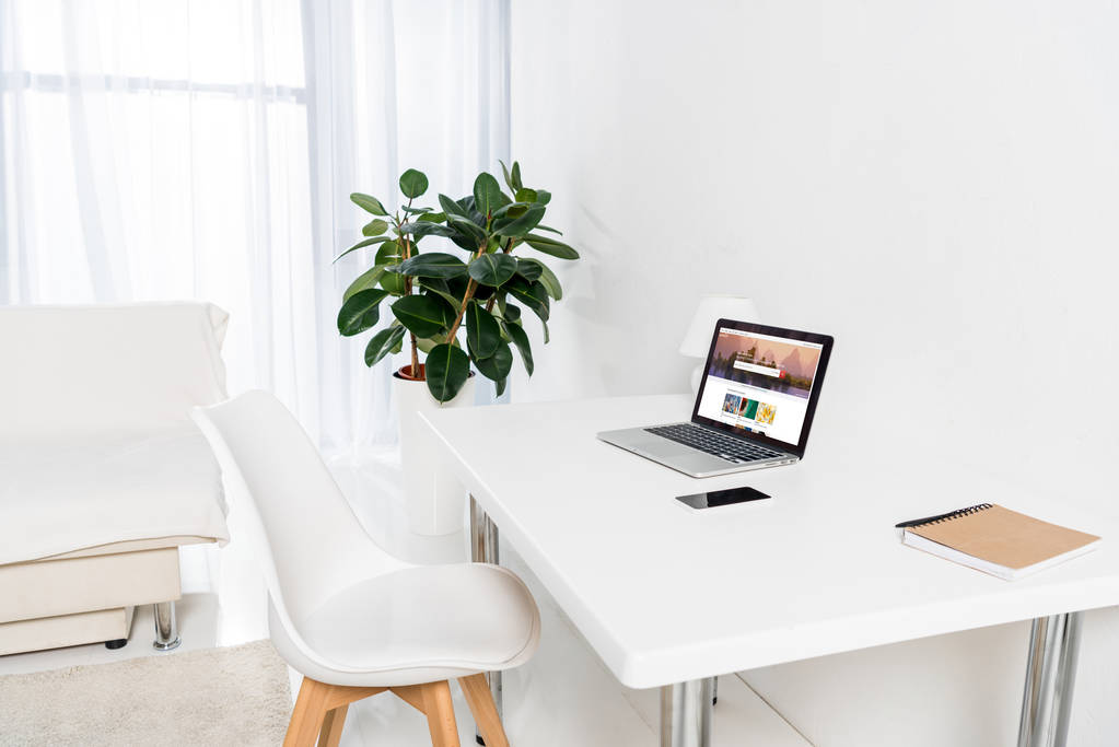 portatile con logo shutterstock, smartphone e notebook sul tavolo in salotto
 - Foto, immagini