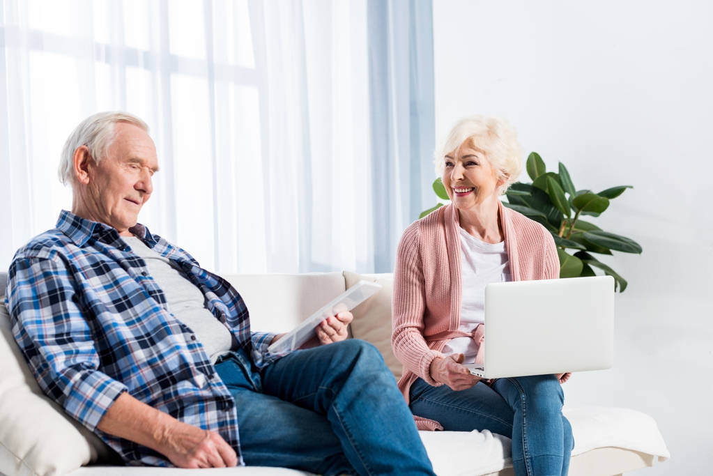 retrato de la esposa y el marido mayores utilizando dispositivos digitales en el hogar
 - Foto, imagen
