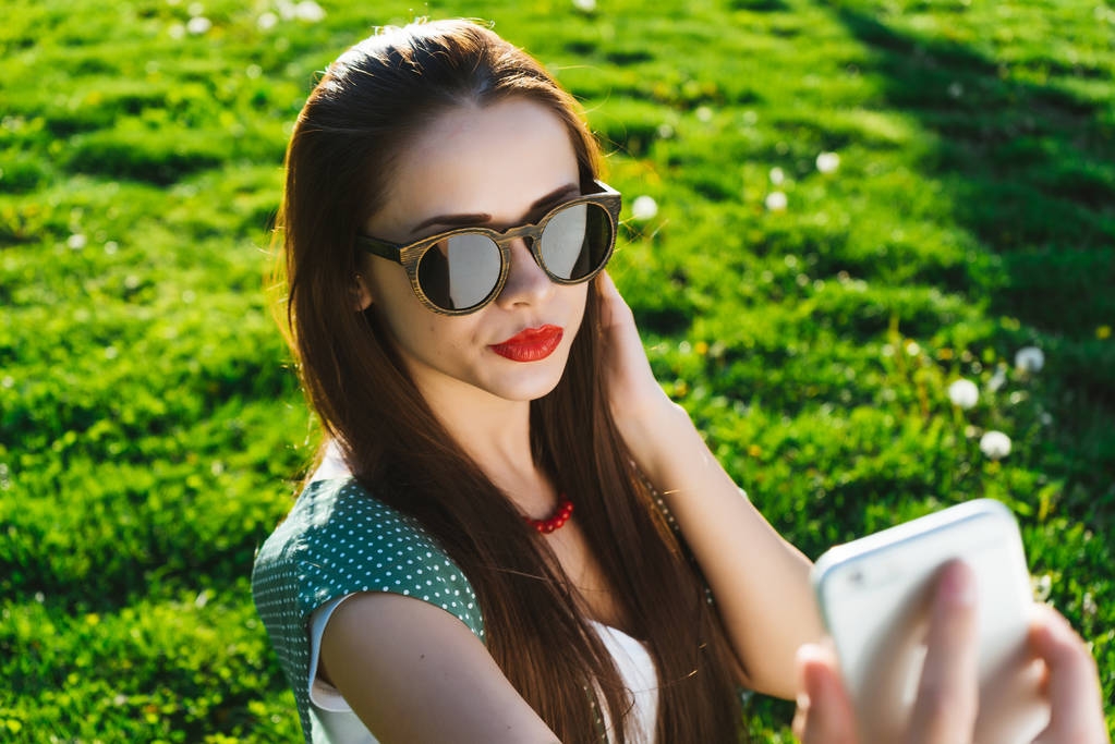 Γυναίκα κάνει selfie έξω, σε ένα χόρτο, copyspace - Φωτογραφία, εικόνα