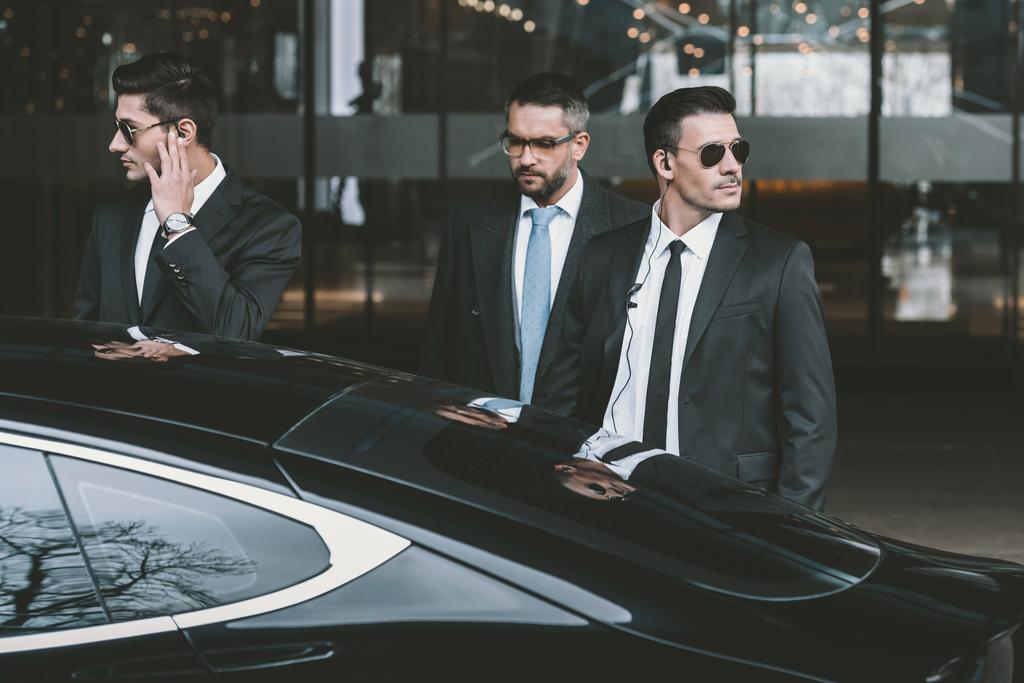 bodyguards going with businessman and reviewing territory near car - Photo, Image