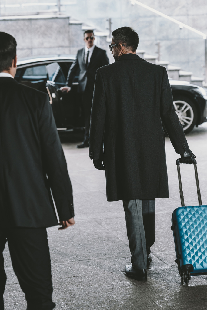 businessman going with blue travel bag to car  - Photo, Image