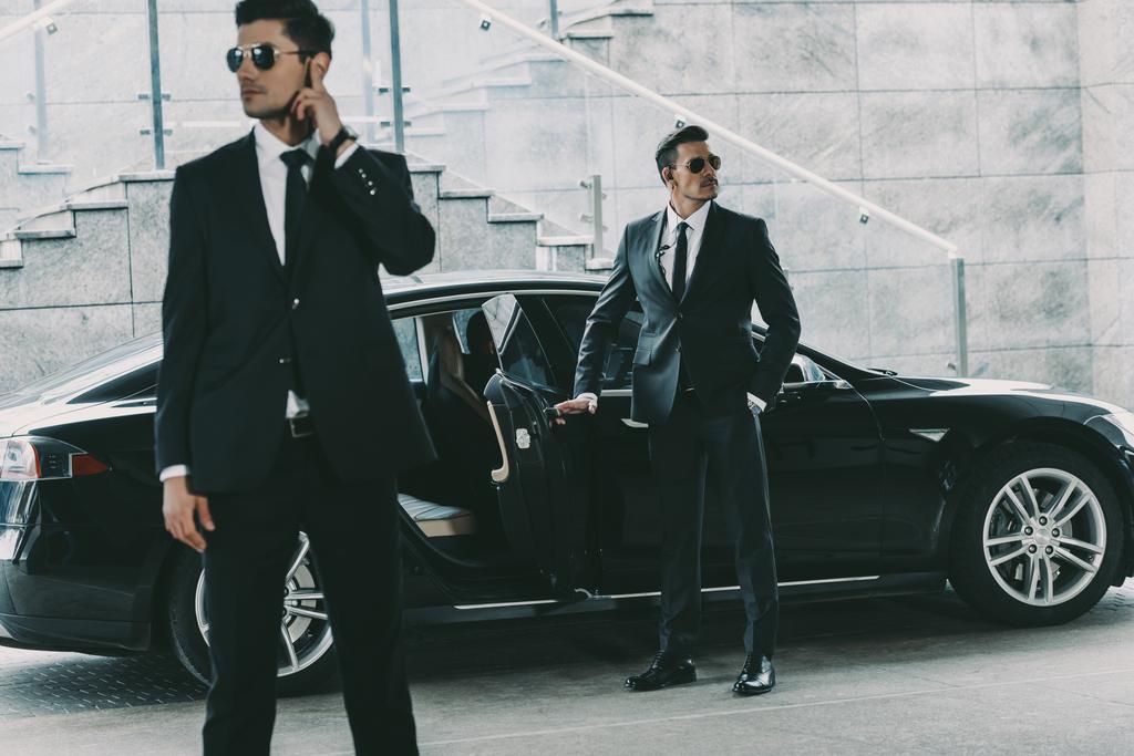 bodyguards in sunglasses standing at car and waiting for politician - Photo, Image