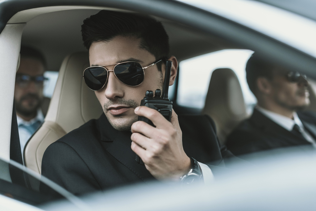bodyguard in sunglasses talking by portable radio  - Photo, Image