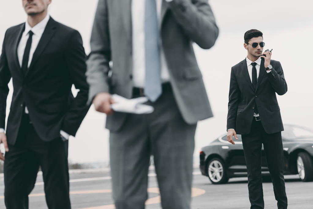 cropped image of bodyguards and businessman walking on helipad  - Photo, Image
