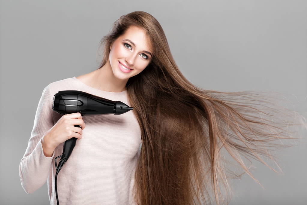 femme séchant ses cheveux avec sèche-cheveux
 - Photo, image