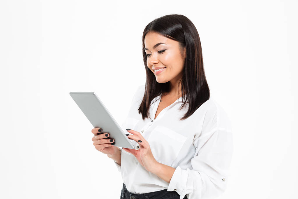 Cheerful young asian lady chatting by tablet computer - Photo, Image