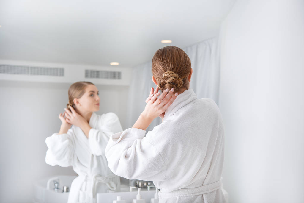 Pensive jeune femme ajuster ses cheveux avant de prendre une douche
 - Photo, image
