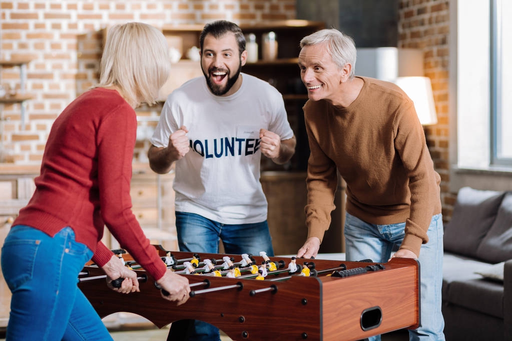 Happy people playing table football at home together - Photo, Image