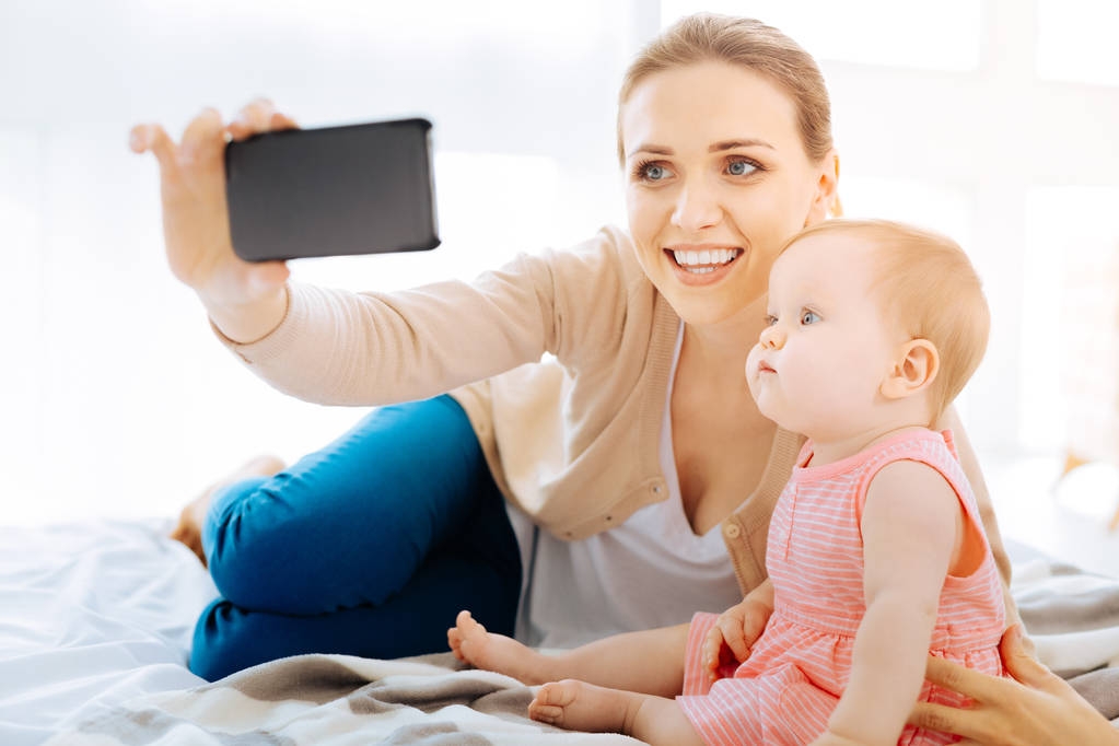 Delighted woman taking photos with her daughter - Photo, Image