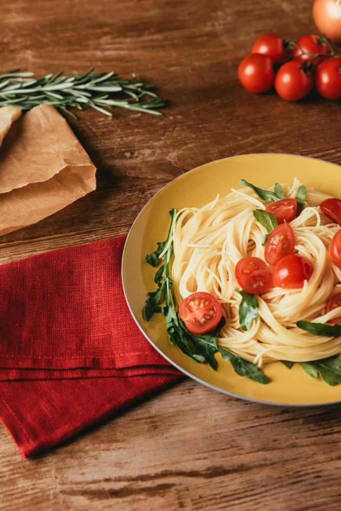 традиционная итальянская паста с помидорами и рукколой в тарелке
 - Фото, изображение