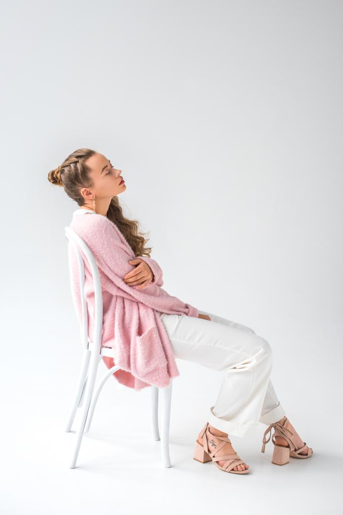 tired girl sitting on white chair with closed eyes on white - Photo, Image