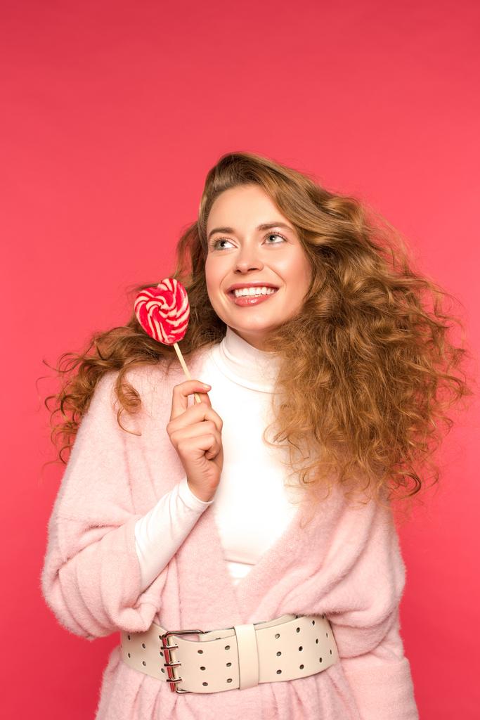 fille souriante tenant sucette en forme de coeur isolé sur rouge
 - Photo, image