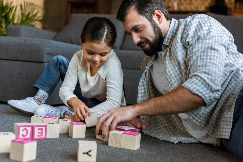 père gai avec fille faire des mots par cubes avec des lettres à la maison
 - Photo, image