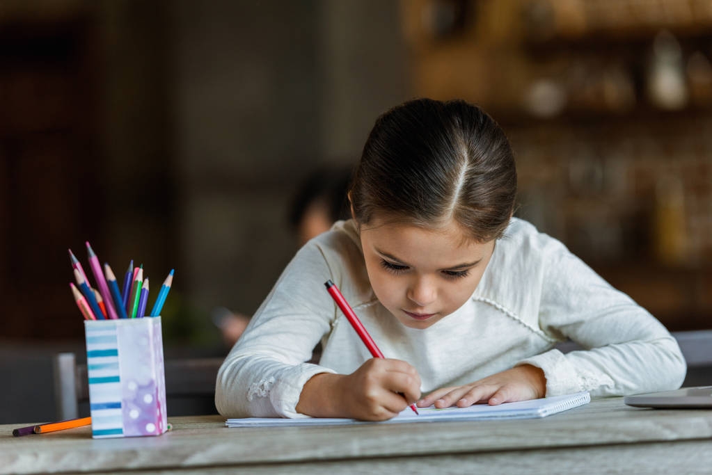 małe dziecko siedzi przy stole i rysunek w Notatniku w domu - Zdjęcie, obraz