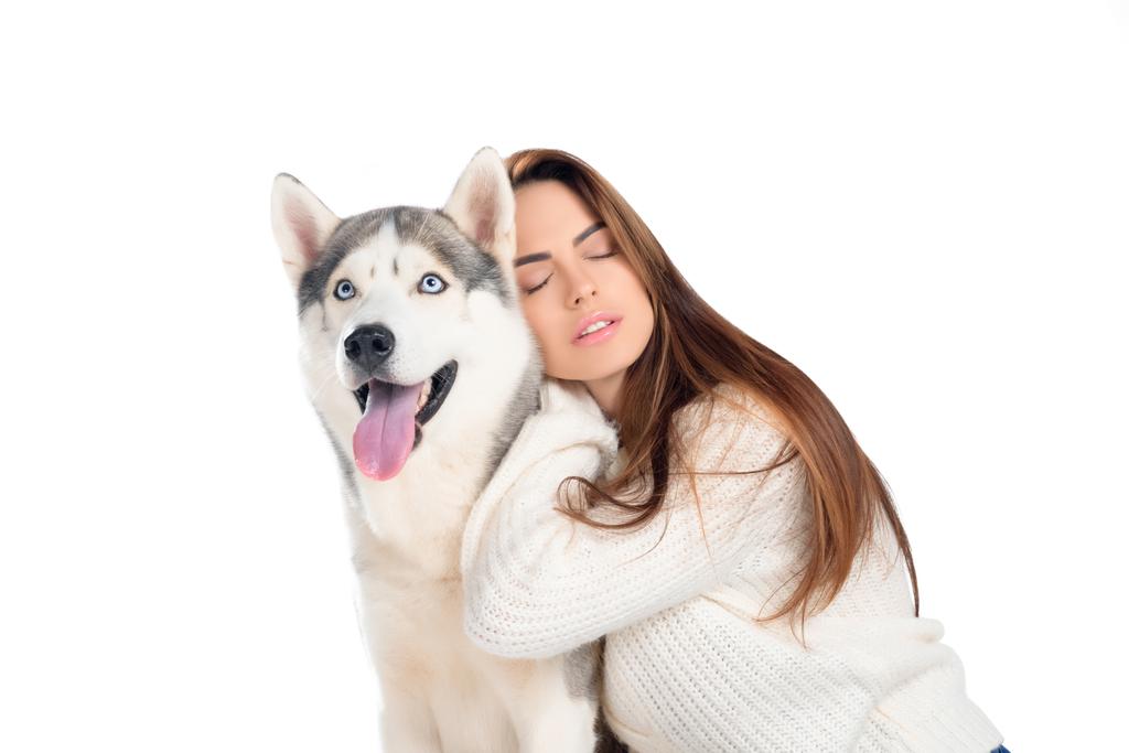 mooi meisje met gesloten ogen husky hond, geïsoleerd op wit knuffelen - Foto, afbeelding