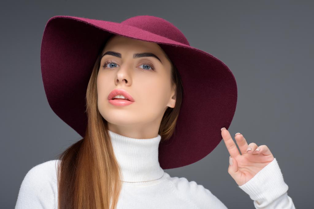 bela senhora posando em chapéu de feltro borgonha, isolado em cinza
 - Foto, Imagem