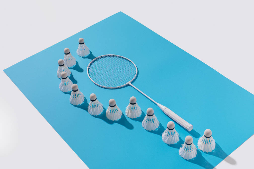 high angle view of badminton racket and shuttlecocks on blue paper - Photo, Image