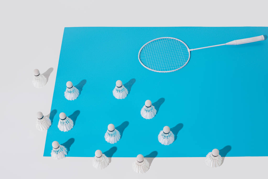 magas szög kilátás fehér tollaslabda ütőt és tollaslabdák kék papírra - Fotó, kép