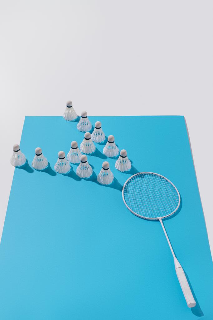 composição com raquete de badminton branco e shuttlecocks em papel azul
 - Foto, Imagem