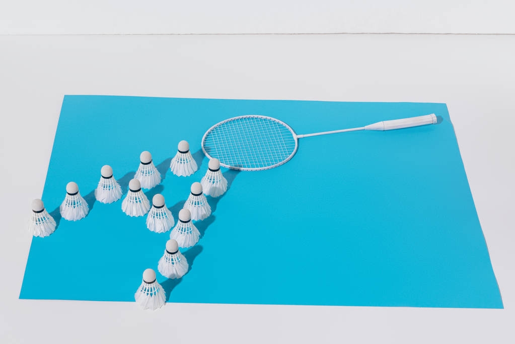 composición con raqueta de bádminton blanco y volantes sobre papel azul
 - Foto, Imagen