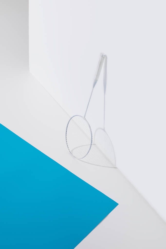 badminton racket at white wall with blue paper near - Photo, Image