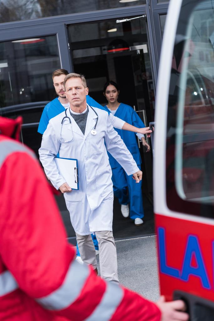 серйозні лікарі йдуть з лікарні до швидкої допомоги
  - Фото, зображення