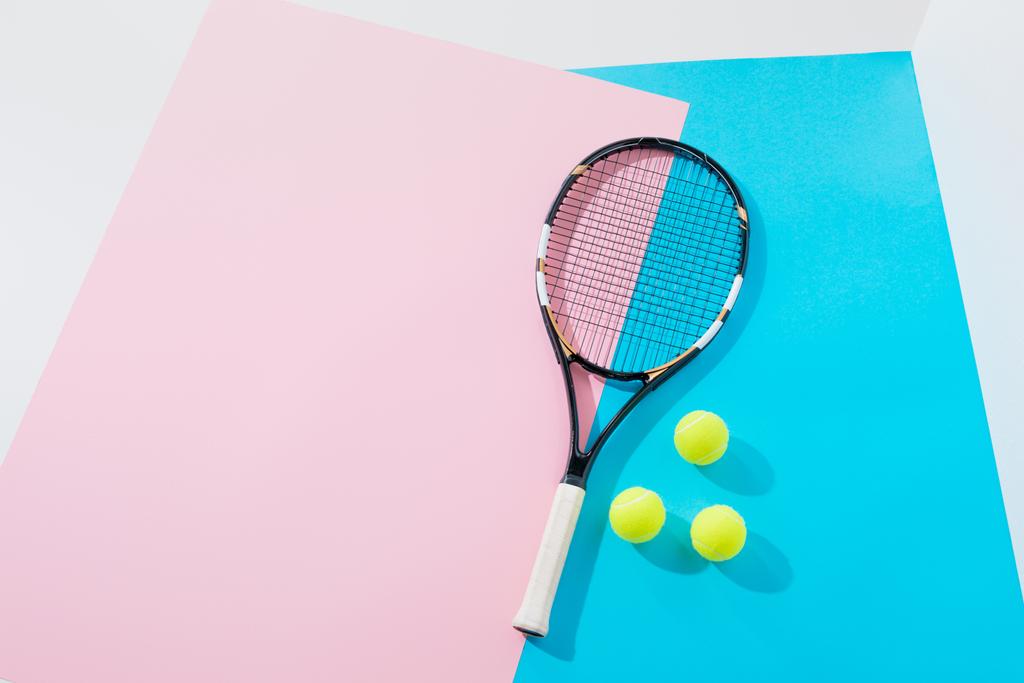 pohled shora tenisovou raketu a žluté kuličky v modré a růžové papíry - Fotografie, Obrázek