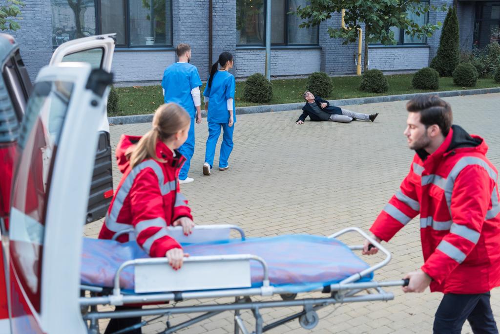 παραϊατρικό προσωπικό λαμβάνοντας φορείο ασθενοφόρων για να βοηθήσει το τραυματισμένο άνθρωπο - Φωτογραφία, εικόνα