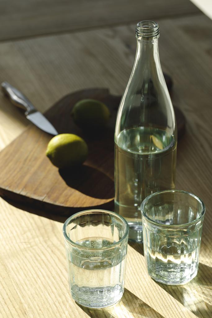 Wasser und Limetten zur Zubereitung von Limonade auf dem Tisch   - Foto, Bild