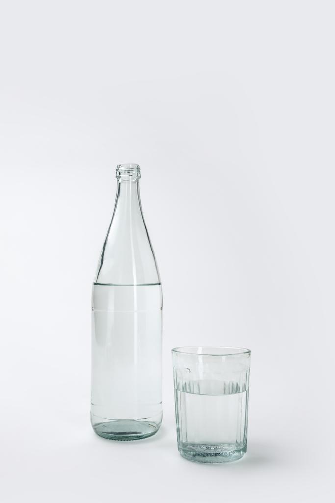 bottle and glass with mineral water isolated on white  - Photo, Image