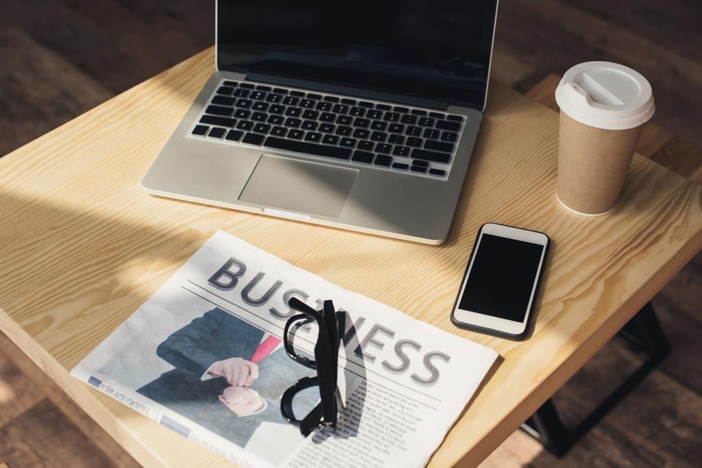 кава-брейк з ноутбуком, смартфоном і бізнес-газетою на столі в кав'ярні
 - Фото, зображення
