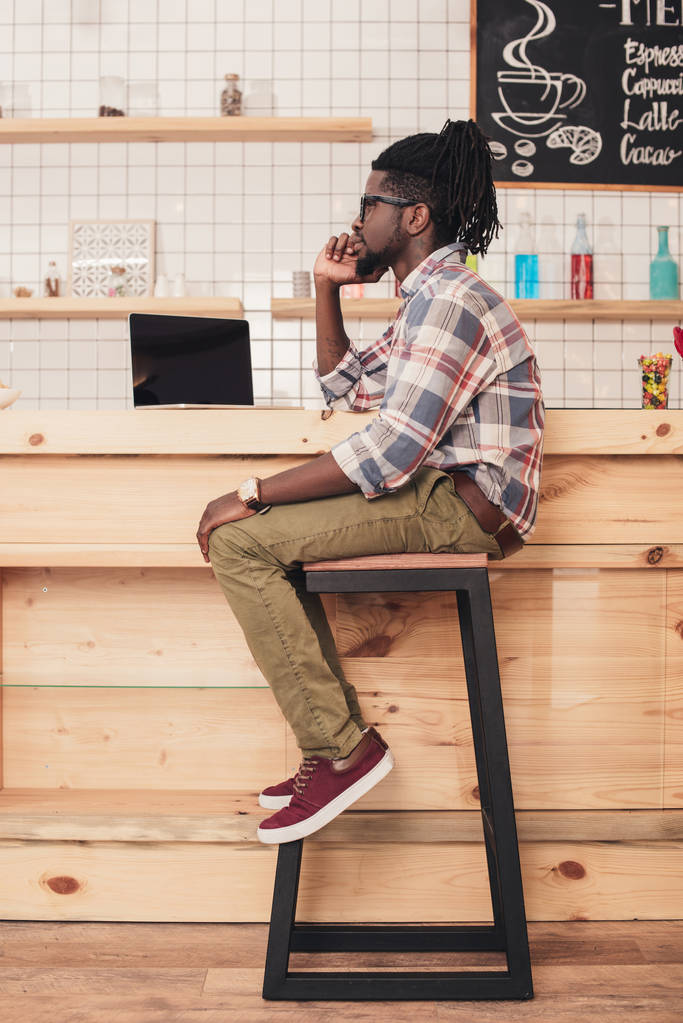 homem americano africano usando laptop no balcão de bar no café
 - Foto, Imagem