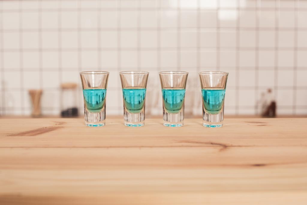 blue cocktails in shot glasses standing on bar counter - Photo, Image