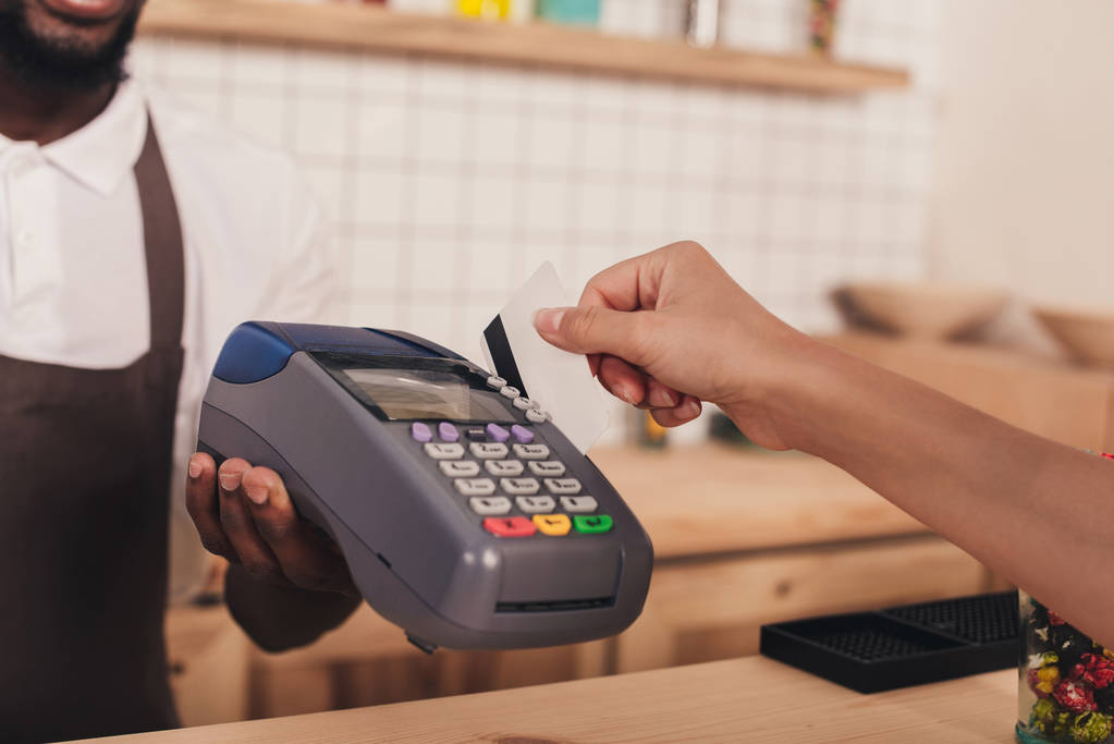обрезанный вид оплаты клиентом кредитной картой и терминалом в кафе
 - Фото, изображение