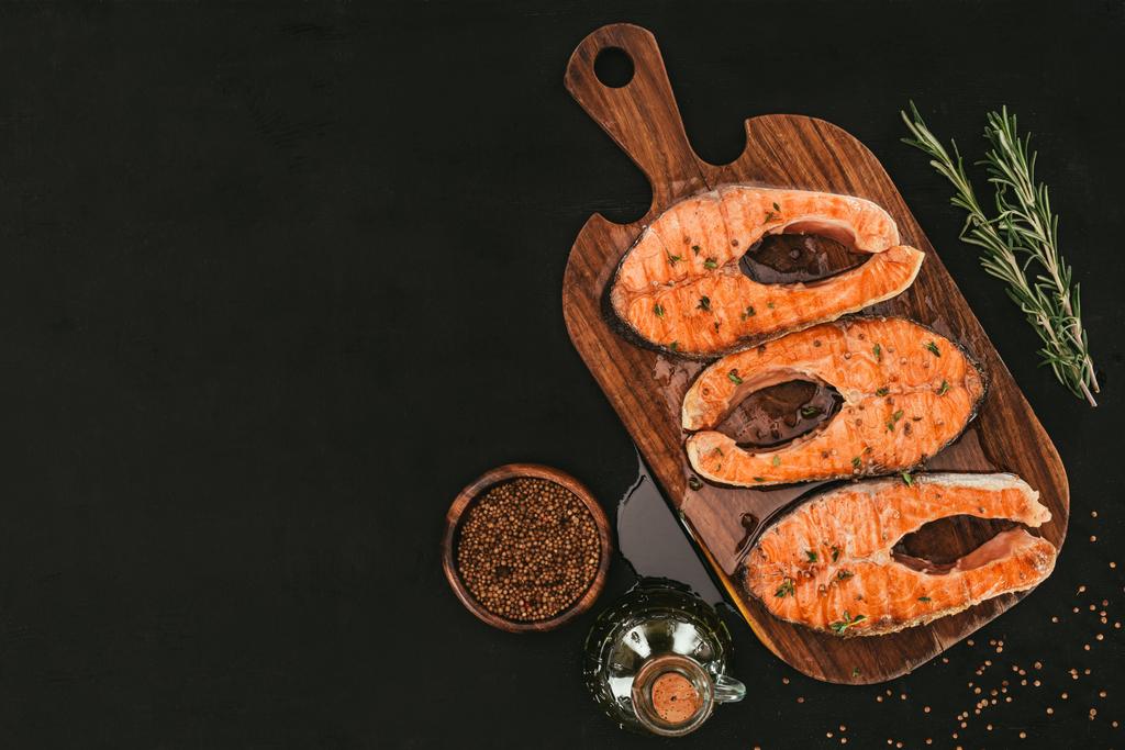 黒のスパイスと木製のまな板にグルメ サーモン ステーキのトップ ビュー  - 写真・画像