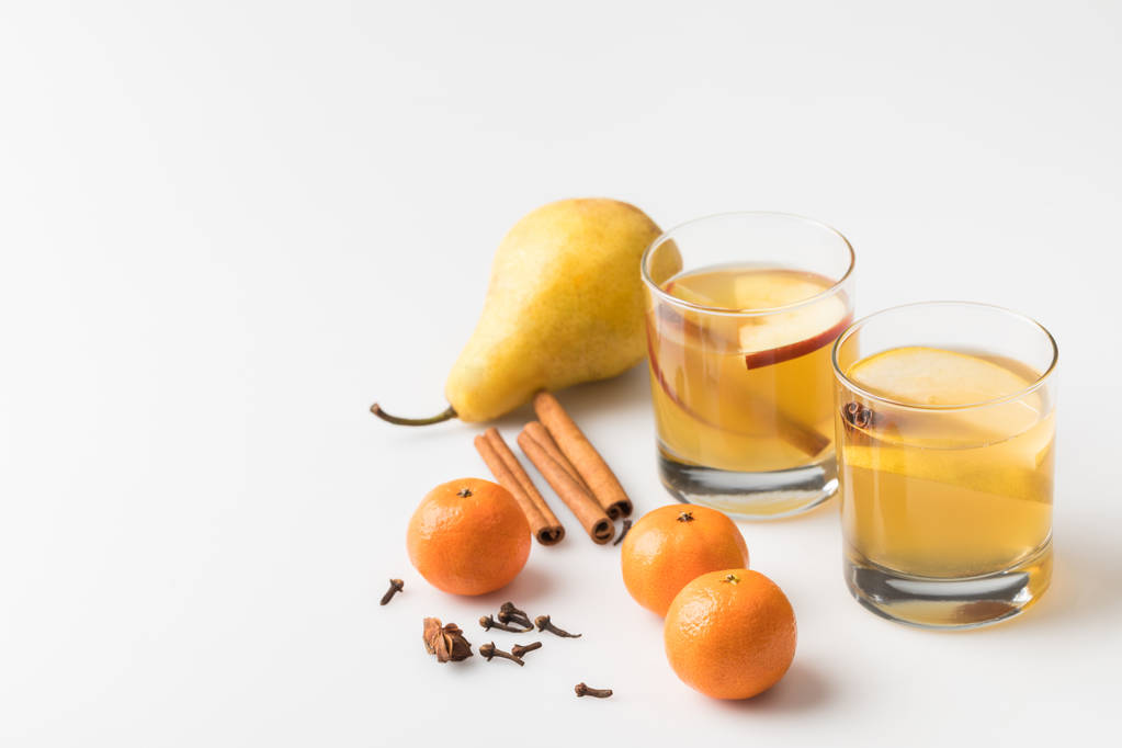 Close-up shot glazen cider met peer en mandarijnen op wit - Foto, afbeelding