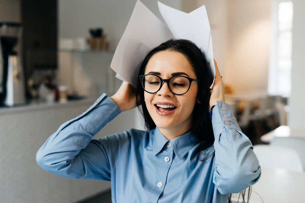 sorrindo mulher de negócios bem sucedida em óculos trabalhando em um café, freelancer, segurando documentos
 - Foto, Imagem