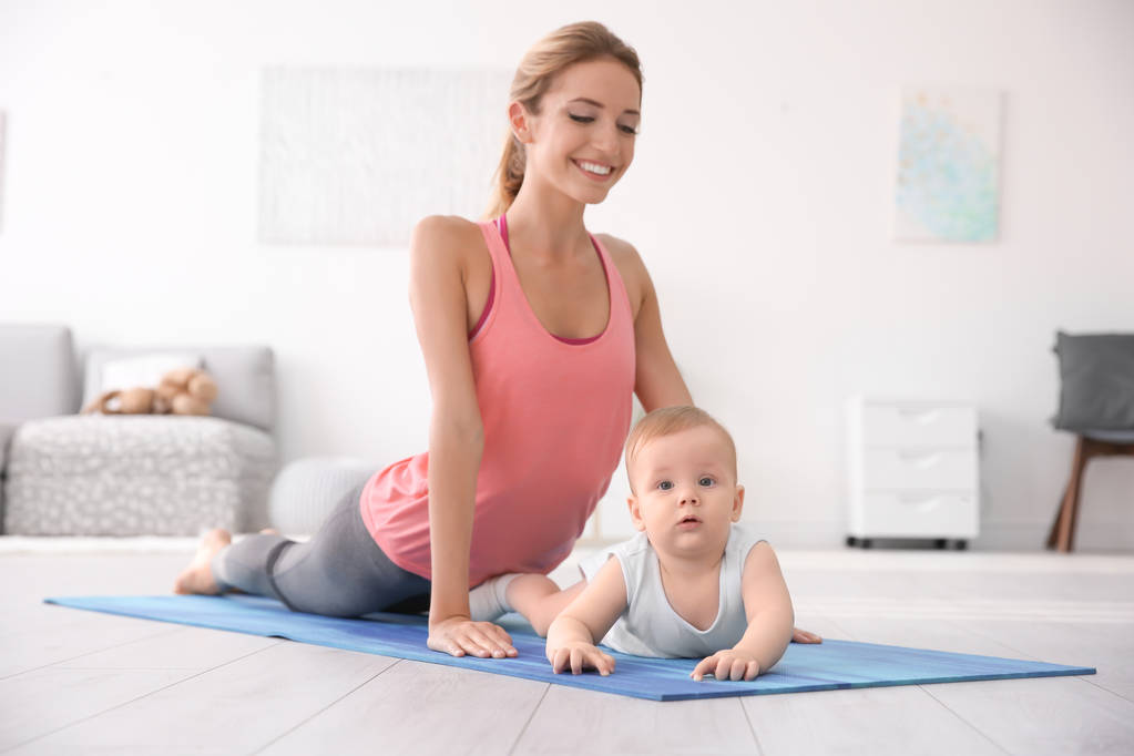 Joven madre haciendo yoga con el bebé en casa
 - Foto, Imagen