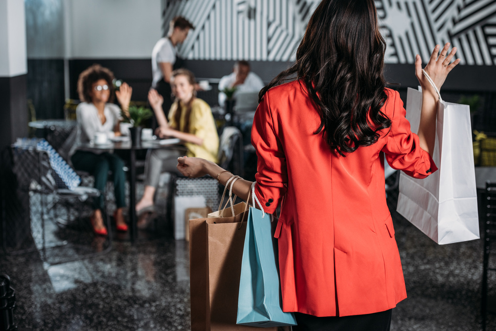 nő, bevásárló táskák megy a kávézó barátai - Fotó, kép