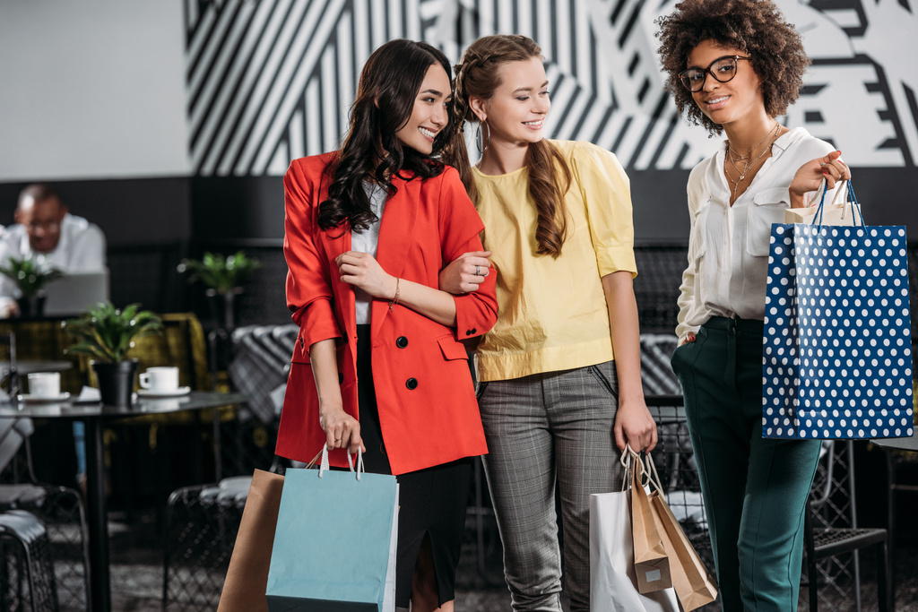 csoport fiatal többnemzetiségű nők a bevásárló szatyrok - Fotó, kép