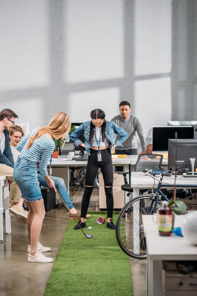 vrolijke collega's spelen in Minigolf op moderne kantoor  - Foto, afbeelding