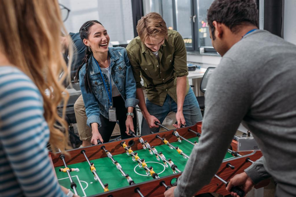 ευτυχισμένος πολυπολιτισμική άνθρωποι που παίζουν στο τραπέζι ποδόσφαιρο στο σύγχρονο γραφείο - Φωτογραφία, εικόνα