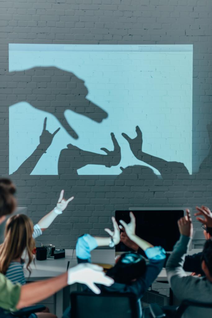 Junge Leute spielen nach der Arbeit im modernen Büro mit Schatten - Foto, Bild