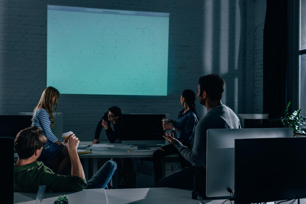 люди смотрят презентации в офисе в ночное время. blank screen
 - Фото, изображение