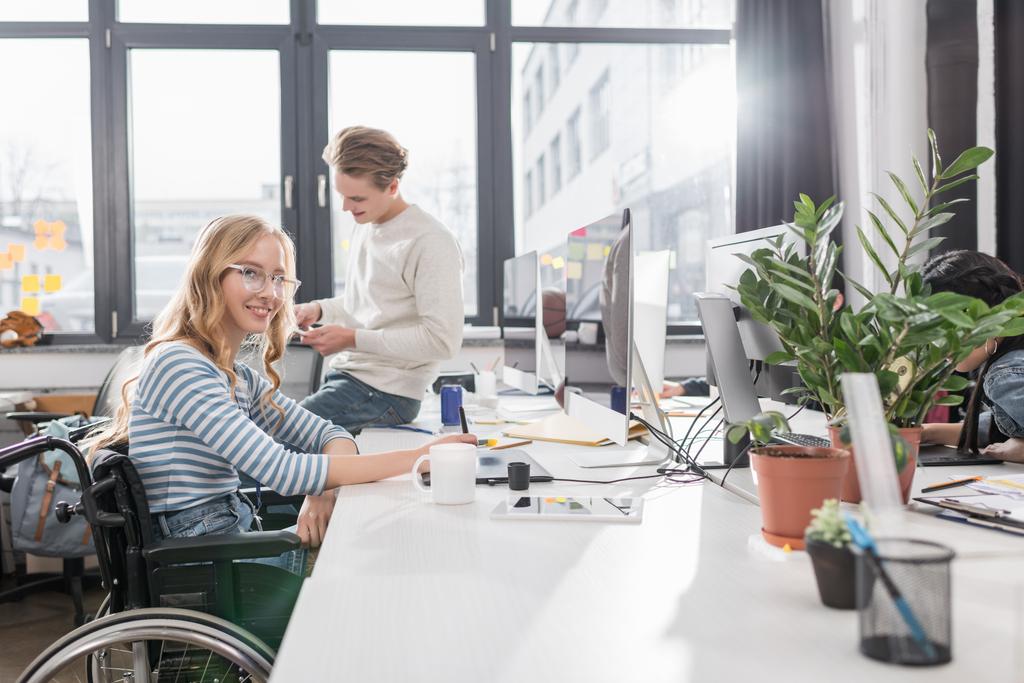 モダンなオフィスで働いている車椅子で幸せな心身障害のある人 - 写真・画像